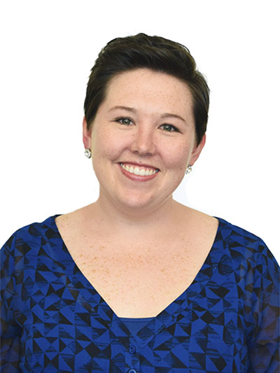 Brooke Web Photo 1 smiling light-skinned woman with short dark hair and a patterned blue shirt