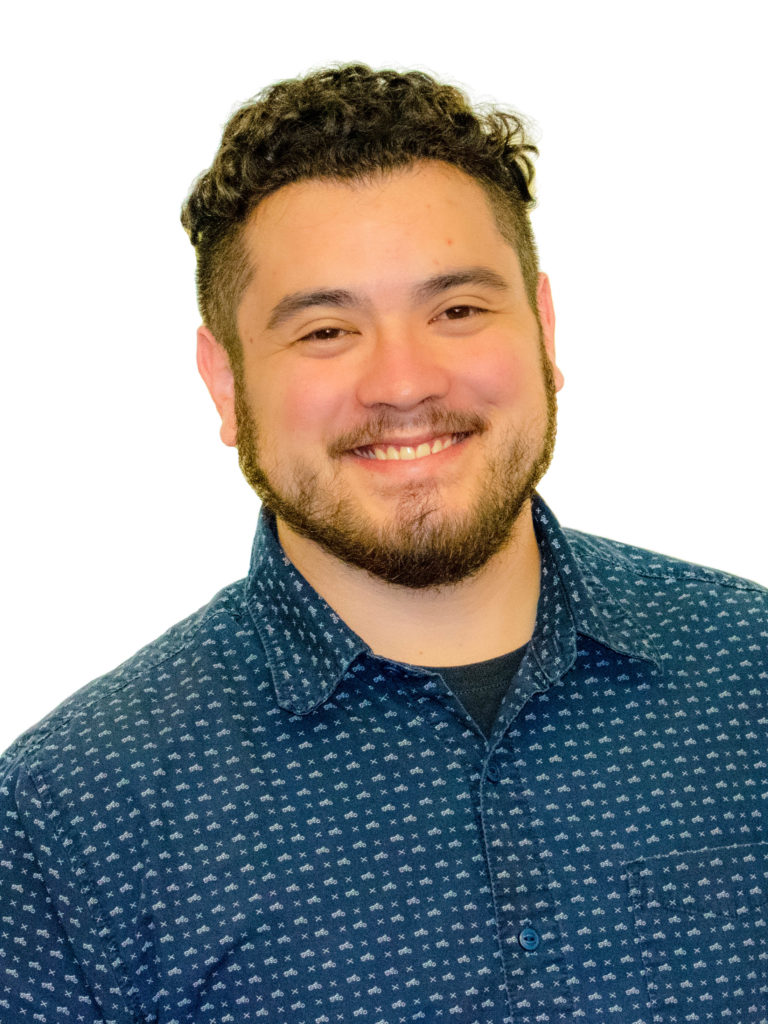 David-3 smiling light-skinned man with dark hair and beard in patterned blue shirt